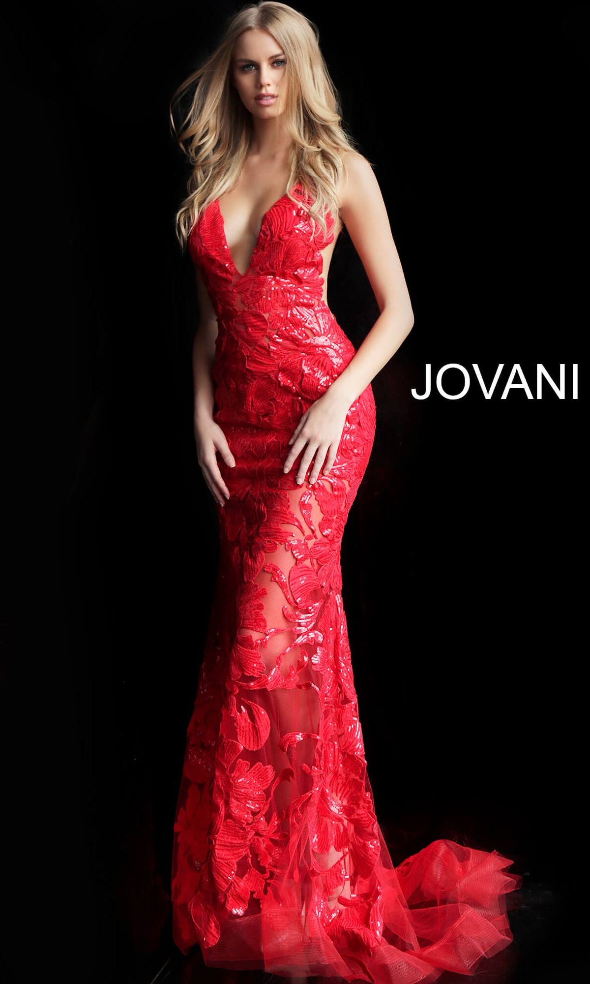 A woman in a fitted, floor-length red Jovani Embroidered Long Prom Dress with sequins stands against a black background with